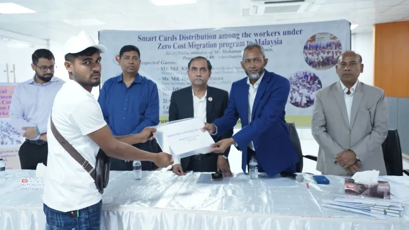 Officials distributing BMET smart cards and travel kits to workers at Trans Asia